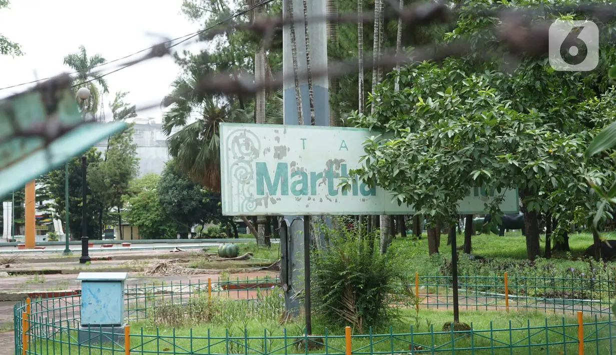 Papan nama Taman Martha Tiahahu yang tertutup ranting pohon, kawasan Blok M, Jakarta, Selasa (18/2/2020). Keasrian dan kenyamanan taman yang memiliki luas 20.960 meter persegi tersebut dinilai terbengkalai dan tak layak menjadi taman kota karena tidak terawat. (Liputan6.com/Immanuel Antonius)
