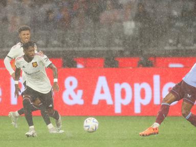 Hujan deras yang turun saat laga uji coba antara Manchester United melawan Aston Villa di Optus Stadium, Perth, Sabtu (23/7/2022) membuat pergerakan sejumlah pemain agak terhambat. (AFP/Trevor Collens)