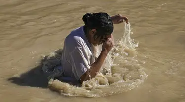 Seorang peziarah Kristen Ortodoks membenamkan dirinya ke Sungai Yordan saat upacara pembaptisan pada perayaan Epiphany di Qasr el Yahud, dekat kota Yerikho, Tepi Barat, 18 Januari 2022. Sungai Yordan dipercaya menjadi tempat di mana Yesus dibaptis. (AP Photo/Mahmoud Illean)