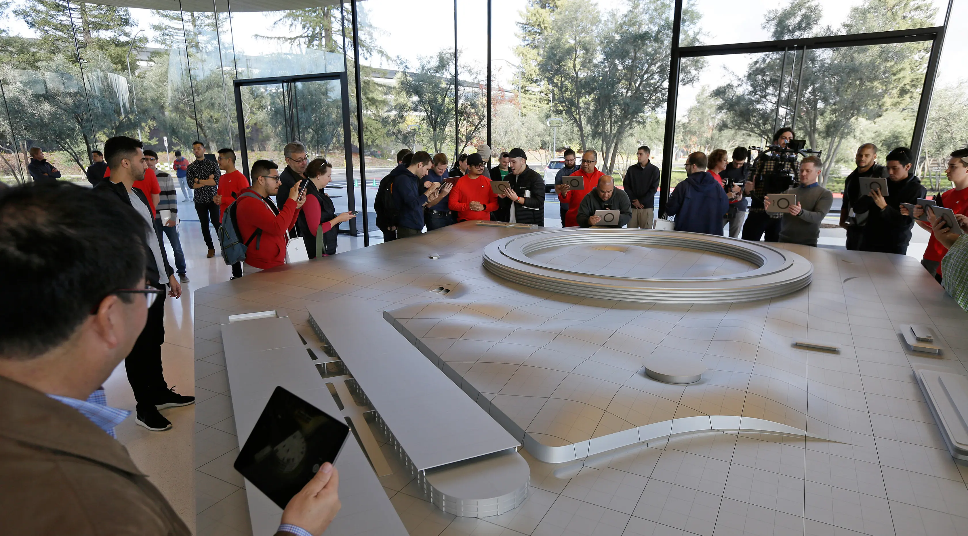 Pengunjung menggunakan iPad saat melihat Augmented Reality (AR) di area khusus Visitor Center kawasan Apple Park di Cupertino, California, Jumat (17/11). Mereka bisa melihat salah satu panel surya terbesar di dunia hadir di Apple Park (AP/Eric Risberg)