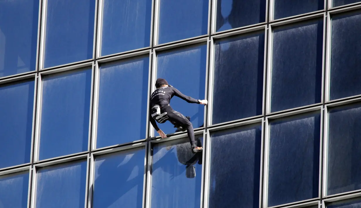Alain Robert atau juga dikenal dengan nama 'Spiderman Prancis' memanjat gedung di pusat bisnis La Defense, Paris, Prancis, Rabu (14/3). Meski sudah menginjak usia 55 tahun, Alain masih melakukan hobi ekstremnya itu. (AP Photo/Francois Mori)