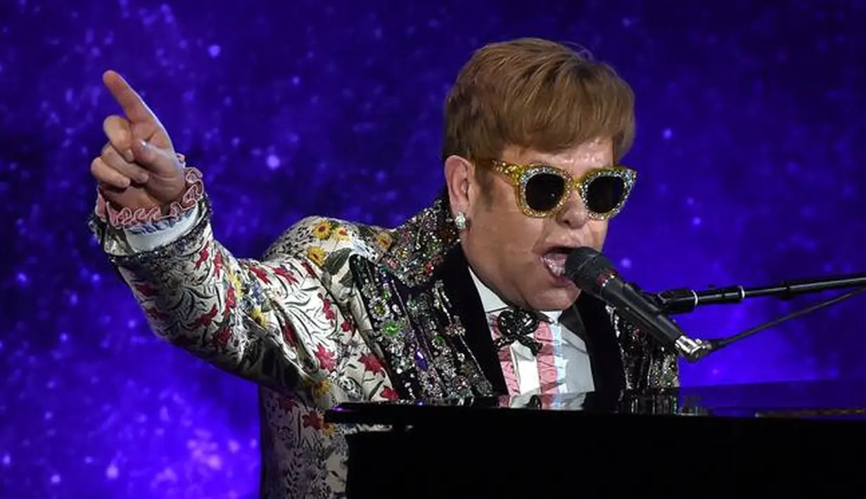 Legenda pop Elton John tampil bernyanyi sambil bermain piano sebelum mengadakan konferensi pers di New York (24/1). Pria 70 tahun ini tercatat sebagai salah satu musisi dengan penjualan terlaris sepanjang masa. (AFP/Timothy A. Clary)