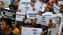 Para pemrotes membawa poster dan spanduk saat mengiringi pemakaman jenazah Kian Loyd delos Santos di Caloocan, Filipina (26/8). Mereka yang ikut mengiringi pemakaman menggunakan kaos putih bertuliskan 'Justice for Kian.' (AP Photo/Bullit Marquez)