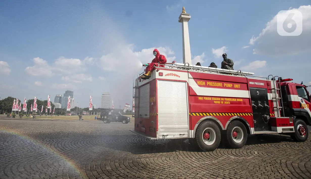 Petugas Pemadam Kebakaran menyemprotkan cairan disinfektan di lingkungan Monas, Jakarta, Rabu (17/6/2020). Penyemprotan dilakukan untuk mencegah penyebaran COVID-19 dalam rangka persiapan pembukaan kembali Monumen Nasional (Monas) pada Sabtu, 20 Juni 2020.  (Liputan6.com/Faizal Fanani)