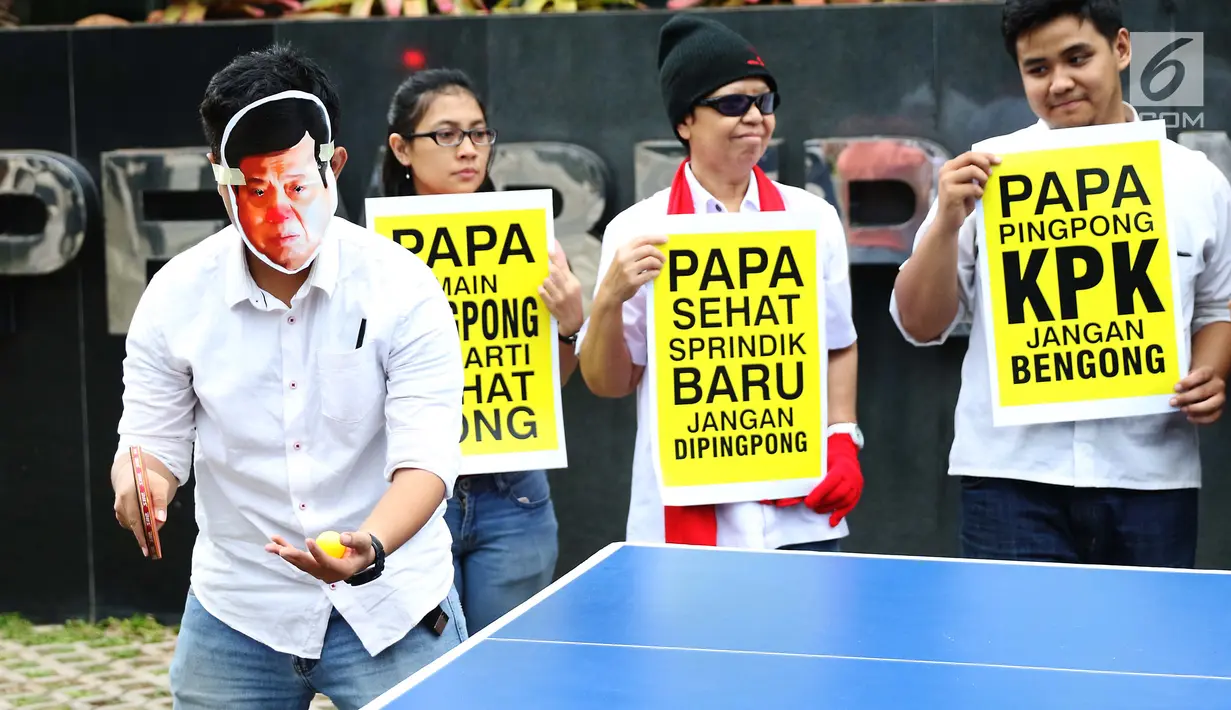 Aktivis yang tergabung dalam Koalisi Save KPK mengenakan topeng wajah Ketua DPR Setya Novanto saat menggelar aksi teatrikal bermain tenis meja melawan KPK di depan gedung KPK, Jakarta, Rabu (18/10). (Liputan6.com/Angga Yuniar)