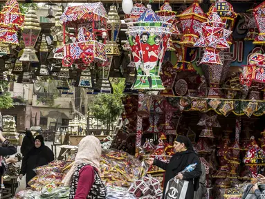 Sejumlah warga mengunjungi toko yang menjual pernak-pernik bertema Mohamed Salah di Kairo, Mesir, Senin (30/5/2018). Menjadi pahlawan baru bagi rakyat Mesir, pernak pernik Mohamad Salah laris manis. (AFP/Khaled Desouki)