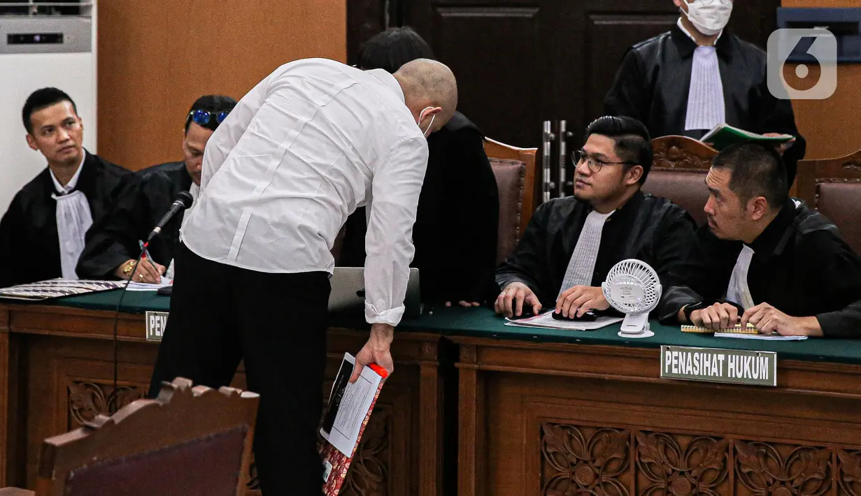 Terdakwa kasus merintangi penyidikan atau 'obstruction of justice' pembunuhan berencana terhadap Brigadir Nopriansyah Yosua Hutabarat (Brigadir J), Baiquni Wibowo berdiskusi dengan tim penasihat hukumnya saat sidang perdana di Pengadilan Negeri Jakarta Selatan, Rabu (19/10/2022). Sidang tersebut beragenda pembacaan surat dakwaan oleh jaksa penuntut umum (JPU). (Liputan6.com/Faizal Fanani)