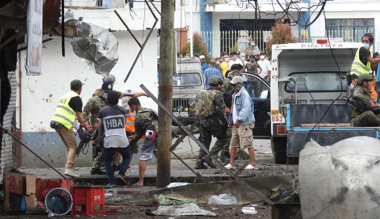 Warga dan tentara membawa tubuh korban usai bom rakitan meledak dekat kendaraan militer di Kota Jolo, Pulau Sulu, Filipina, Senin (24/8/2020). Sebanyak 10 orang tewas dan puluhan lainnya terluka -banyak dari mereka tentara atau polisi- dalam pemboman ganda tersebut. (Nickee BUTLANGAN/AFP)