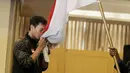 Atlet Bulutangkis Indonesia, Mohammad Ahsan, mencium bendera saat acara pelepasan di Hotel Atlet Century, Senayan, Selasa (8/5/2018). Acara pelepasan tersebut sekaligus merayakan ulang tahun PBSI ke 67. (Bola.com/M Iqbal Ichsan)