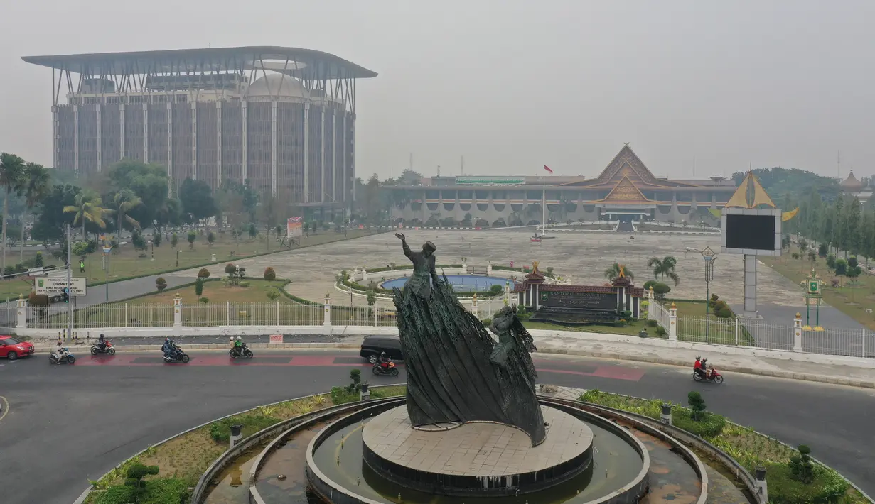 Gambar udara menunjukkan Tugu Zapin ketika kabut asap pekat menyelimuti Pekanbaru, Riau, Minggu (15/9/2019). Menurut BMKG, kualitas udara di wilayah Pekanbaru masih terpantau tidak sehat pada Minggu pagi. (ADEK BERRY/AFP)