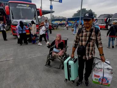 Peserta mudik gratis berjalan menuju bus di Terminal Pondok Cabe, Tangerang Selatan, Banten, Kamis (27/3/2025). (merdeka.com/Arie Basuki)