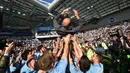 Pelatih Manchester City, Pep Guadiola, diangkat pemainnya saat merayakan gelar juara Liga Inggris di Stadion American Express Community, Brighton, Minggu (12/5). City juara setelah unggul satu poin dari Liverpool. (AFP/Glyn Kirk)
