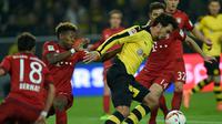 Bek Borussia Dortmund, Mats Hummels (tengah), saat berusaha mengamankan bola dari jangkauan para pemain Bayern Munchen, pada pertandingan lanjutan Bundesliga, di Stadion Signal Iduna Park, Sabtu (5/3/2016). (AFP/Patrik Stollarz). 