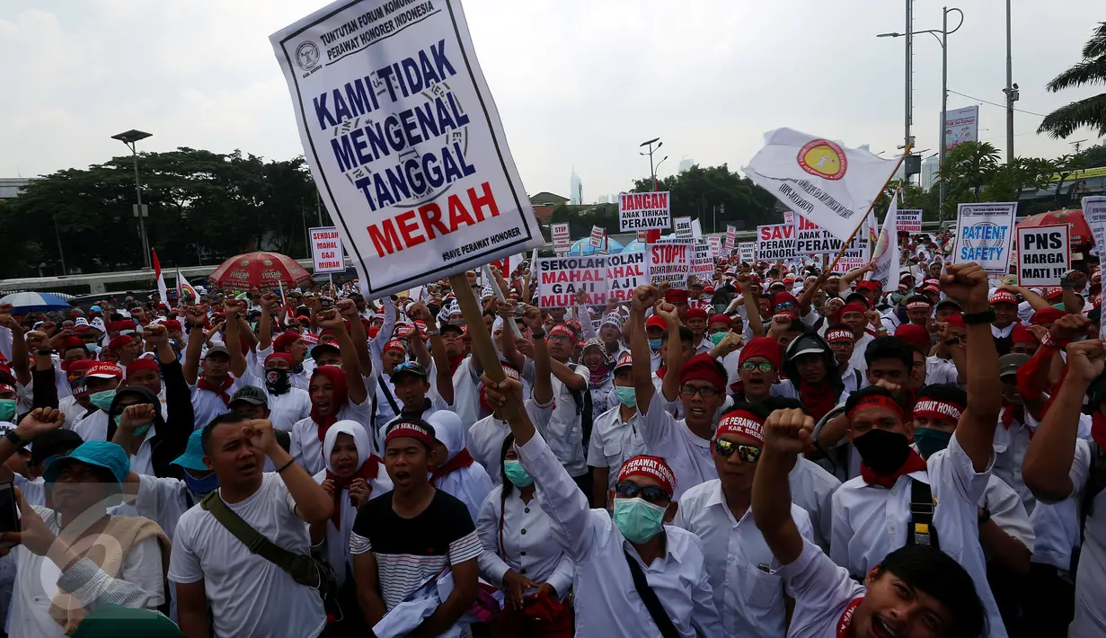 Ratusan massa dari para perawat honorer Indonesia melakukan unjuk rasa di depan Gedung DPR, Jakarta, Kamis (16/3). Dalam unjuk rasanya mereka meminta pemerintah khususnya DPR untuk diangkat menjadi Pegawai Negeri Sipil (PNS).(Liputan6.com/Johan Tallo)