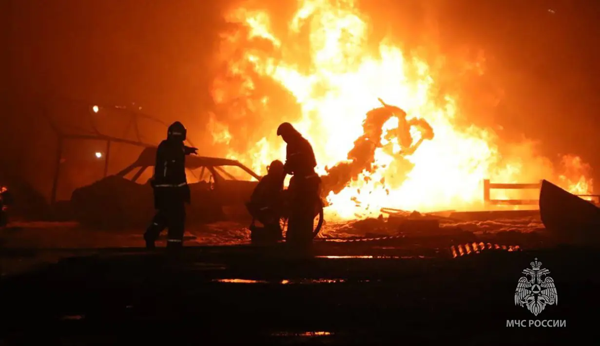 Foto selebaran ini diambil dan dirilis oleh Kementerian Darurat Rusia pada 14 Agustus 2023, menunjukkan penyelamat memadamkan api di sebuah pompa bensin di Kota Makhachkala. (Handout/RUSSIAN EMERGENCY MINISTRY/AFP)