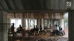 Pengendara motor melintasi jalan setapak di kolong tol di kawasan Lebak Bulus, Jakarta, Selasa (13/2). Untuk menghindari macet sebagian pengendara memanfaatkan jalan setapak tersebut untuk memersingkat waktu tempuh. (Liputan6.com/Immanuel Antonius)