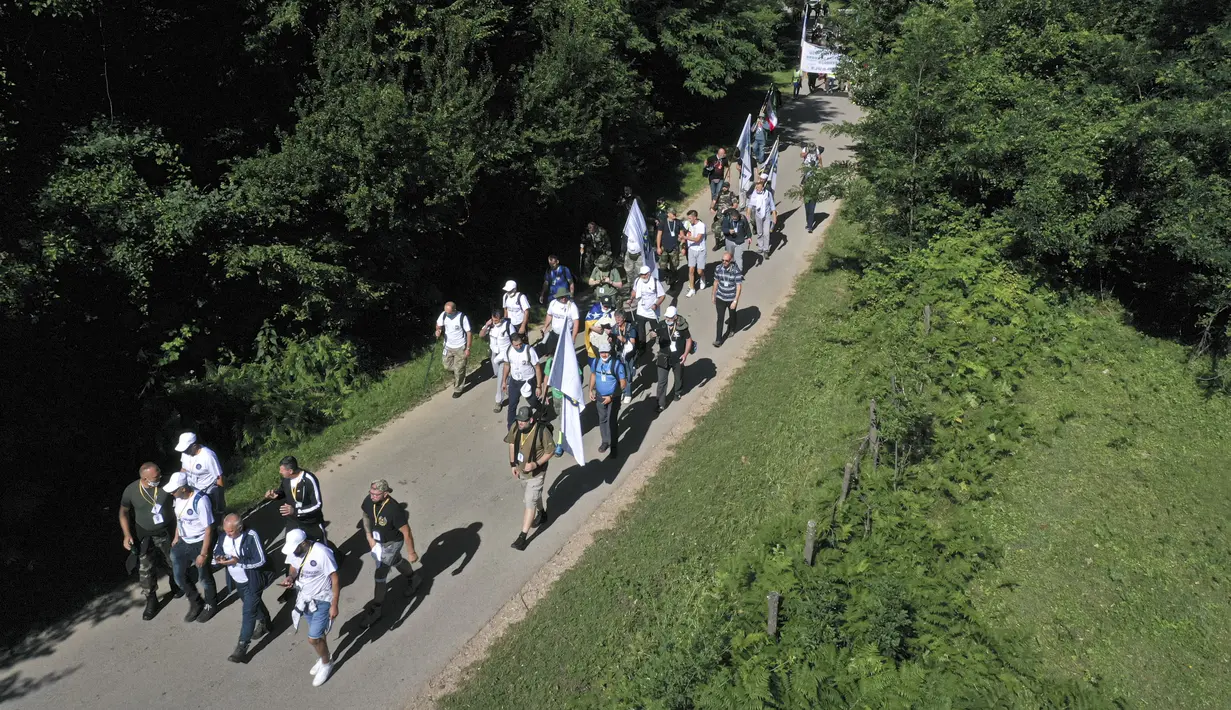 Rakyat Bosnia berjalan melalui daerah pegunungan dekat Crni Vrh saat memperingati 25 tahun pembantaian Srebrenica di Bosnia, Rabu (8/7/2020). Acara tersebut untuk mengenang lebih dari 8.000 orang yang tewas selama 10 hari pembantaian setelah Srebrenica diserbu pasukan Serbia. (AP Photo/Kemal Softic)