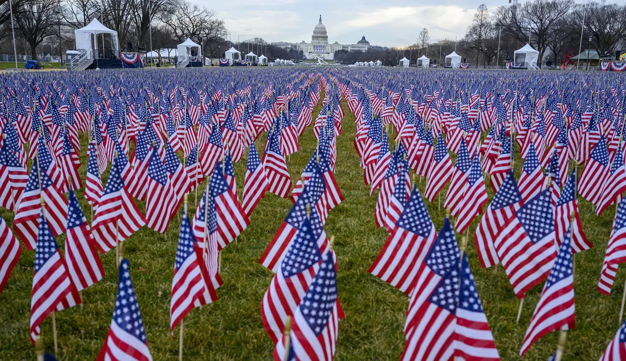 Ribuan bendera terlihat di National Mall menjelang upacara pelantikan Joe Biden sebagai presiden Amerika Serikat (AS) ke-46 di Washington, DC., Senin (18/1/2021). Tidak boleh ada kerumunan massa, dan pandemi virus corona membuat kursi-kursi tamu pelantikan harus diberi jarak. (Eric BARADAT/AFP)