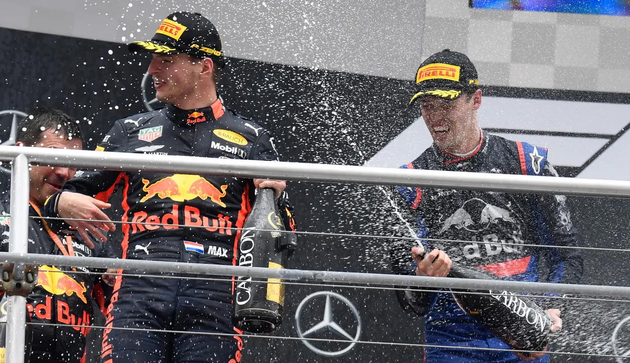 Pebalap Red Bull Max Verstappen disemprot menggunakan sampanye oleh pebalap Daniil Kvyat usai dirinya memenangkan F1 GP Jerman di Hockenheimring, Hockenheim, Minggu (28/7/2019). Ini adalah kemenangan kedua Verstappen pada persaingan F1 GP 2019. (AP Photo/Jens Meyer)