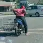 Seorang pengendara motor bertingkah aneh saat memacu kendaraannya di jalan raya.