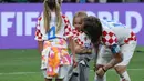 Kapten Kroasia, Luka Modric mencium anaknya, Ema saat timnya berhasil menyabet peringkat ketiga Piala Dunia 2022 setelah mengalahkan Maroko dengan skor 2-1 pada laga yang berlangsung di Khalifa International Stadium, Doha, Qatar, Sabtu (17/12/2022). (AFP/Karim Jaafar)