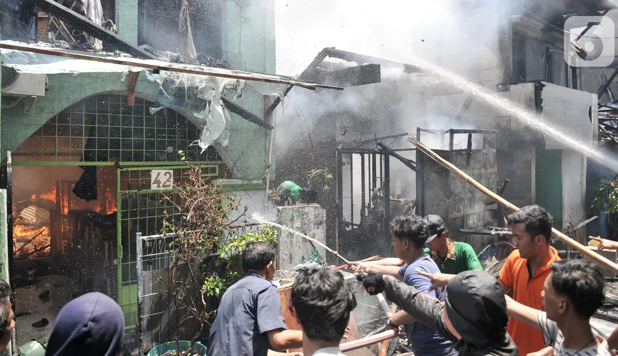 Warga berusaha memadamkan api yang membakar permukiman di Jalan Kebon Jeruk 13, Taman Sari, Jakarta Barat, Minggu (6/10/2019). Kebakaran diduga akibat anak bermain korek api. (merdeka.com/Iqbal Nugroho)