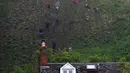 Peserta berlari menuruni bukit curam untuk mengejar keju dalam kompetisi Cheese Rolling di Cooper's Hill di Brockworth, Gloucestershire, Inggris, Senin (28/5). Peserta berebut 1,5 kilogram keju yang digelindingkan dari atas bukit. (Aaron Chown/PA via AP)
