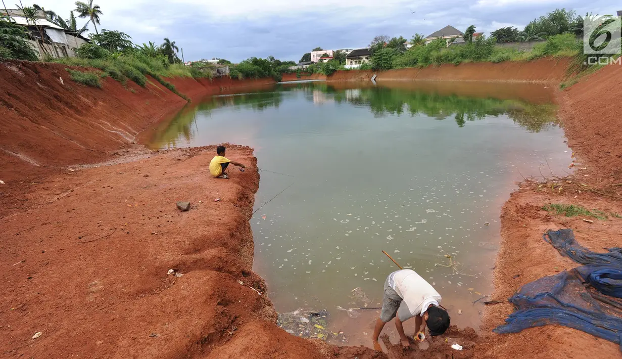 Anak-anak memancing pada bagian proyek pembangunan tol Cinere-Serpong yang berubah menjadi danau sedalam 4 meter di kawasan Cipayung, Tangsel, Banten (17/1). Pembangunan jalan Tol ini sepanjang 10,14 kilometer. (Merdeka.com/Arie Basuki)