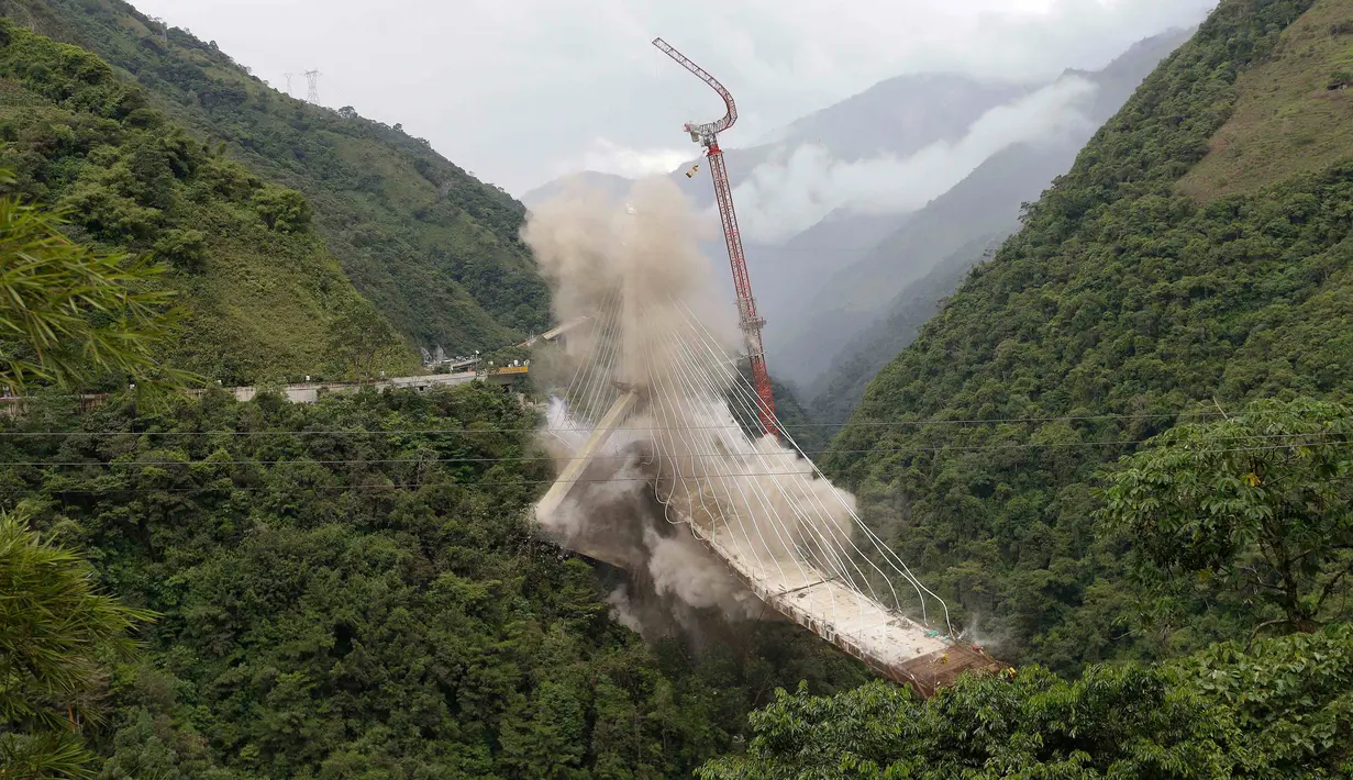 Peruntuhan sebuah jembatan gantung oleh para insinyur di Chirajara, Kolombia, Rabu (11/7). Sebelumnya, sebagian jembatan runtuh dan menewaskan sembilan pekerja saat pembangunannya pada Januari lalu. (AP Photo/Fernando Vergara)