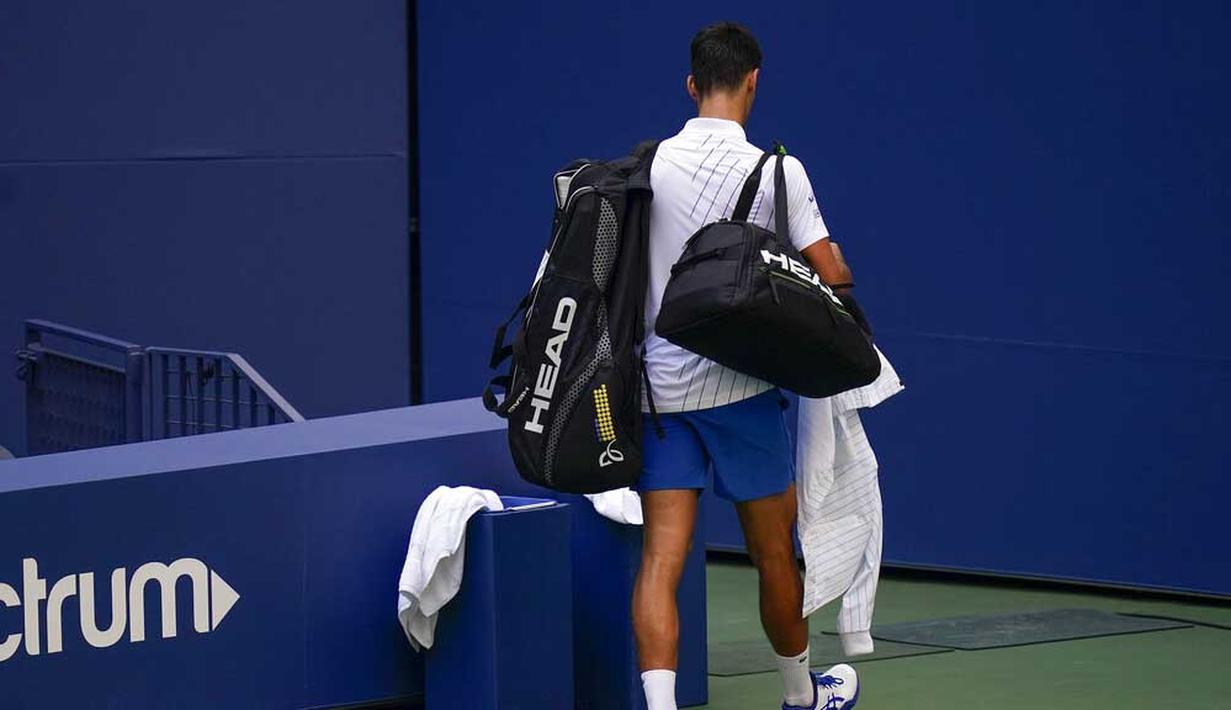 Petenis Serbia, Novak Djokovic, meninggalkan lapangan usai didiskualifikasi pada AS Terbuka di Flushing Meadows, Senin (7/9/2020). Djokovic didiskualifikasi karena memukulkan bola tenis ke arah hakim garis. (AP/Seth Wenig)
