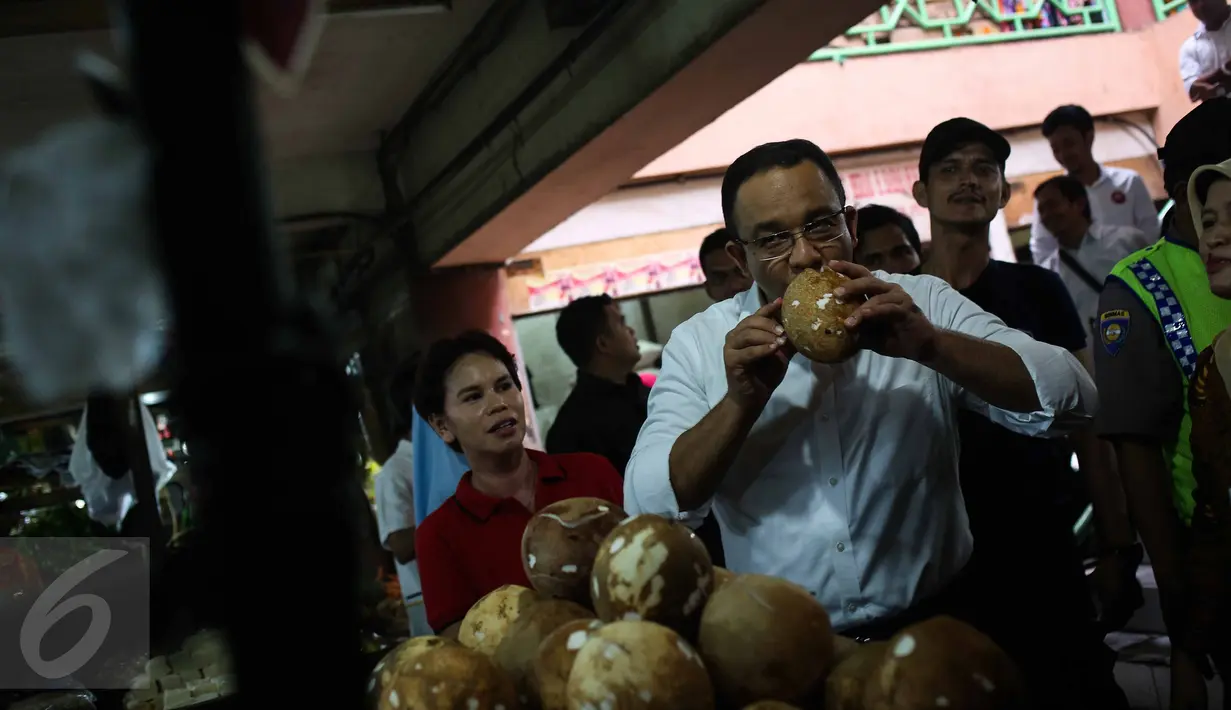 Cagub DKI Jakarta Anies Rasyid Baswedan mencium kelapa saat kunjungi Pasar Tebet Timur, Jakarta, Jumat (28/10). Kunjungan Anis tersebut untuk melihat suasana pasar tradisional serta sebagai kampanye Pilgub DKI Jakarta 2017. (Liputan6.com/Faizal Fanani)