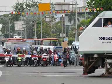  Sejumlah kendaraan menunggu kereta commuterline di perlintasan sebidang Stasiun Pasar Seen, Jakarta, (13/9). Ditjen Perkeretaapian Kemenhub akan menutup perlintasan sebidang di Jalan Letjen Soeprapto, Jakarta Pusat. (Liputan6.com/Gempur M Surya)