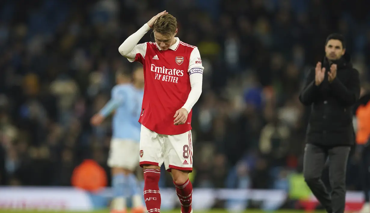 Gelandang Arsenal, Martin Odegaard tertunduk usai pertandingan melawan Manchester City pada putaran keempat Piala FA di Stadion Etihad di Manchester, Inggris, Sabtu (28/1/2023). Kekalahan ini membuat Arsenal gagal lolos ke putaran kelima Piala FA 2022-2023. (AP Photo/Dave Thompson)