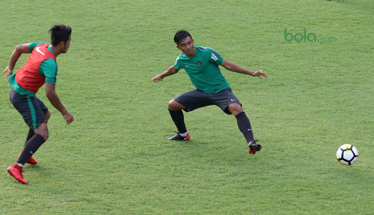 Aksi pemain Timnas Indonesia U-23, I Putu Gede (kiri) memberikan umpan melewati rekannya pada sesi latihan di Lapangan A,B,C, Senayan, Jakarta (18/2/2018). Latihan ini merupakan persiapan Asian Games 2018. (Bola.com/Nick Hanoatubun)