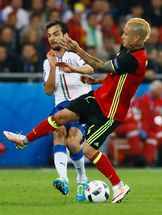 Gelandang Belgia, Radja Nainggolan (kanan) berebut bola dengan gelandang Italia, Marco Parolo pada pertandingan grup E Piala Eropa di Stade de Lyon, Prancis, (14/6). Italia menang atas Belgia dengan skor 2-0. (REUTERS/Kai Pfaffenbach)
