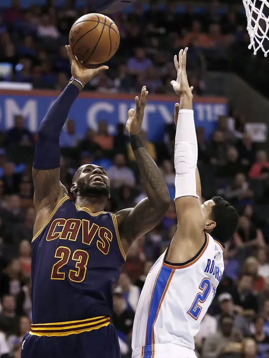Pebasket Cleveland Cavaliers, LeBron James, dihadang pebasket Oklahoma City Thunder, Andre Roberson. Pada laga ini LeBron hanya mampu mencetak 18 poin. (EPA/Larry W.Smith)