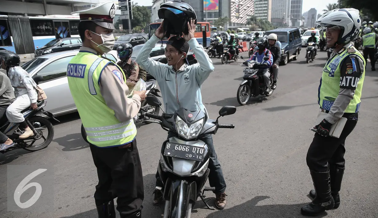 Petugas memberhentikan pengendara roda dua saat operasi patuh jaya dikawasan Thamrin, Jakarta, Selasa (24/5/2016). Selama Operasi Patuh Jaya 2016, Ditlantas Polda Metro Jaya mencatat terjadi 38.622 pelanggar lalu lintas. (Liputan6.com/Faizal Fanani)