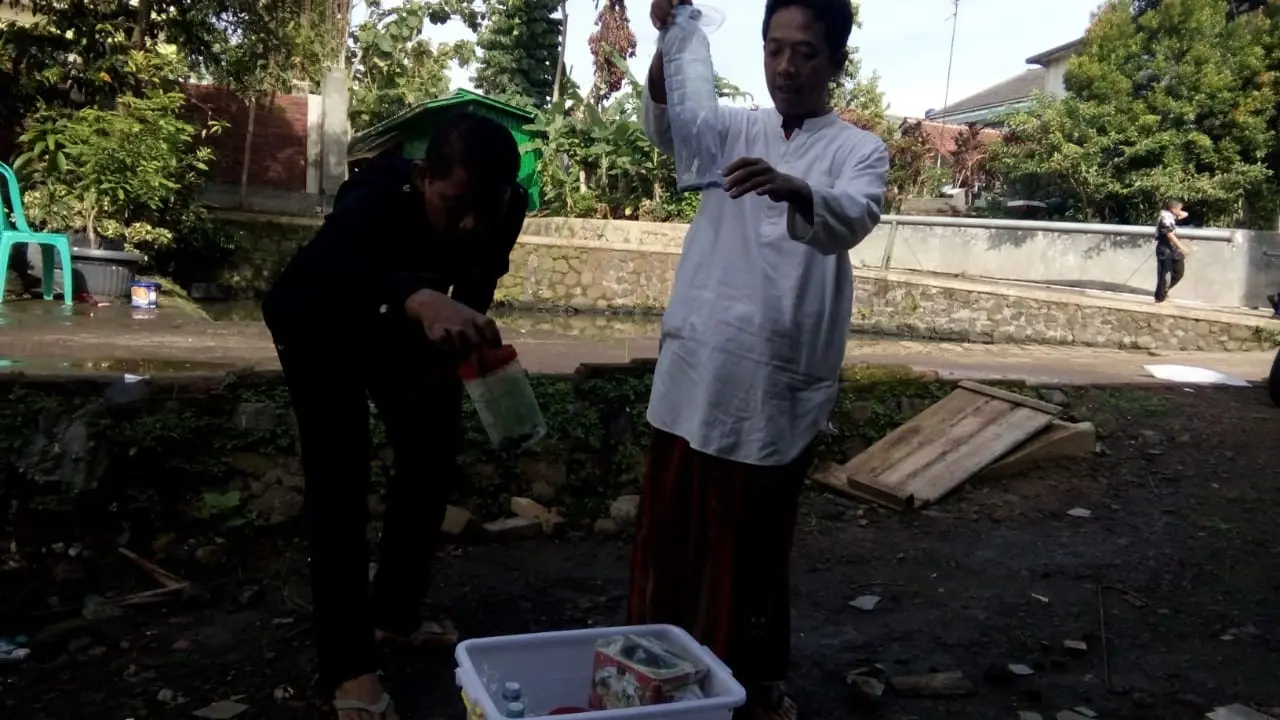 Dibantu pengajar, nampak eguh Prayoga (15), Siswa kelas X SMA Terpadu Pondok Pesantren Riyadul Ulum Waddawah Condong, Kota Tasikmalaya, tengah memasukan beberapa ular kobra ke dalam bekas air mineral