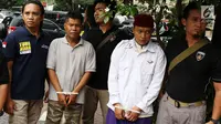 Petugas membawa dua terduga pelaku persekusi U dan M di Polda Metro Jaya, Jakarta, Jumat (2/6). Reskrim Polres Jaktim menangkap dua pelaku persekusi terhadap PMA, 15 tahun, karena diduga menghina FPI dan Rizieq Syihab. (Liputan6.com/Immanuel Antonius)