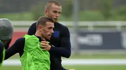 Gelandang Inggris, Jordan Henderson berebut bola dengan Eric Dier saat latihan di St George's Park di Burton-on-Trent, Inggris tengah (4/9). Inggris akan bertanding melawan Spanyol laga persahabatan internasional 8 September. (AFP Photo/Paul Ellis)