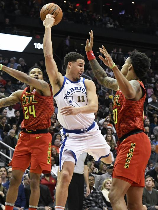 Pemain Warriors, Klay Thompson #11 memberikan umpan kepada rekannya saat diadang dua pemain Atlanta Hawks pada laga NBA basketball game  di Philips Arena, Atlanta, (2/3/2018). Warriors menang 114-109. (AP/John Amis)