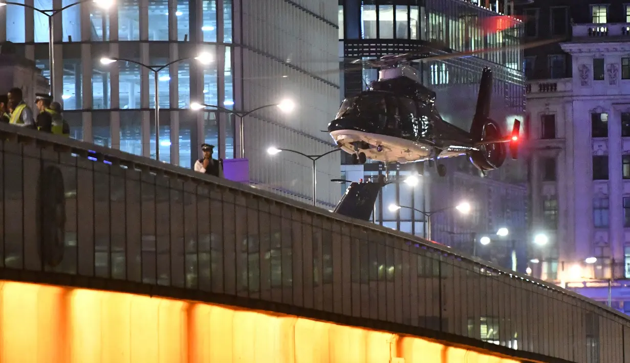 Sebuah helikopter mendarat di London Bridge, setelah serangan teror, pusat kota London, Sabtu (3/6). Sebuah van diketahui menabraki pejalan kaki di London Bridge dan membuat 7 orang tersungkur. (Dominic Lipinski/PA via AP)