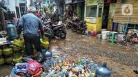 Warga beres-beres usai banjir di Kebalen, Jakarta, Minggu (21/2/2021). Banjir yang terjadi kemarin karena curah hujan yang tinggi meninggalkan sampah di rumah warga. (Liputan6.com/Johan Tallo)