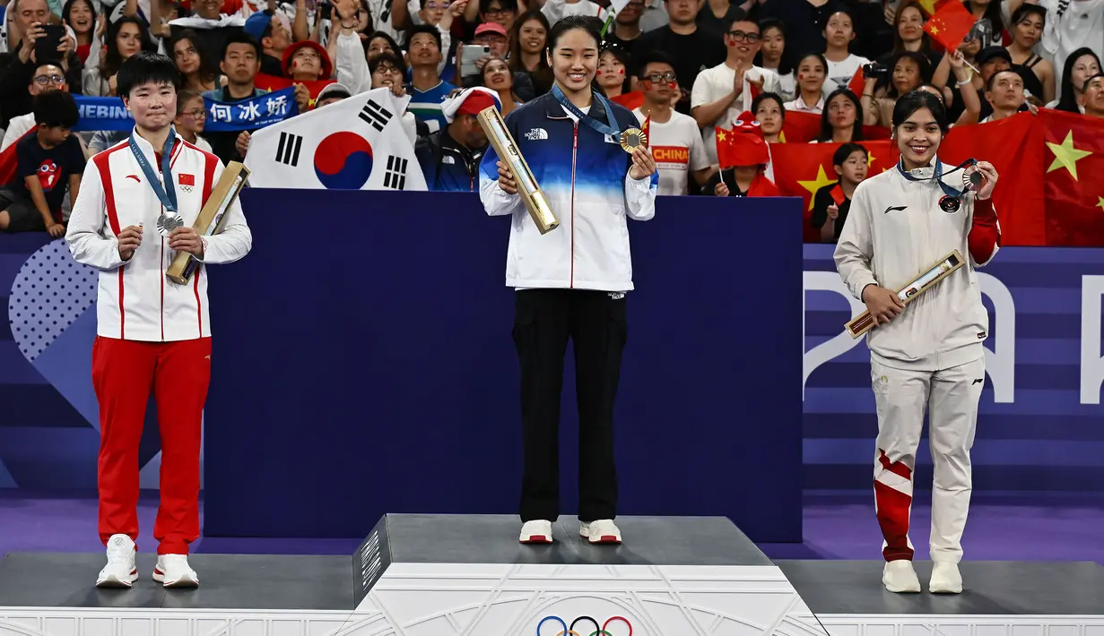 (Dari kiri) pebulu tangkis China peraih medali perak, He Bing Jiao, peraih medali emas An Se-young (Korea Selatan) dan peraih medali perunggu Gregoria Mariska Tunjung (Indonesia) berpose di atas podium saat upacara penyerahan medali nomor tunggal putri cabor bulu tangkis Olimpiade Paris 2024 di Porte de La Chapelle Arena, Paris, Senin (5/8/2024). (Dok. NOC Indonesia/Antara/Wahyu Putro A)