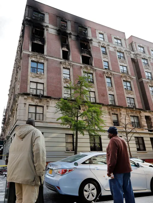 Warga melihat kondisi apartemen yang rusak setelah dilanda kebakaran di kawasan Harlem, New York, Amerika Serikat, Rabu (8/5/2019). Kebakaran terjadi diduga akibat kompor yang dibiarkan menyala semalaman. (AP Photo/Richard Drew)