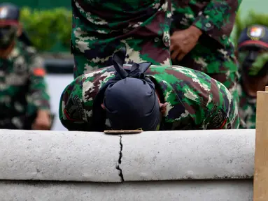 Prajurit TNI Yonif Raider 112/Dharma Jaya mematahkan pipa beton dengan kepalanya saat atraksi dalam upacara sertijab di Banda Aceh, Aceh, Rabu (18/9/2019). Mayor Inf Syarifuddin Liwang menjadi Komandan Yonif Raider 112/Dharma Jaya menggantikan Mayor Inf Agus Alfauzi. (CHAIDEER MAHYUDDIN/AFP)