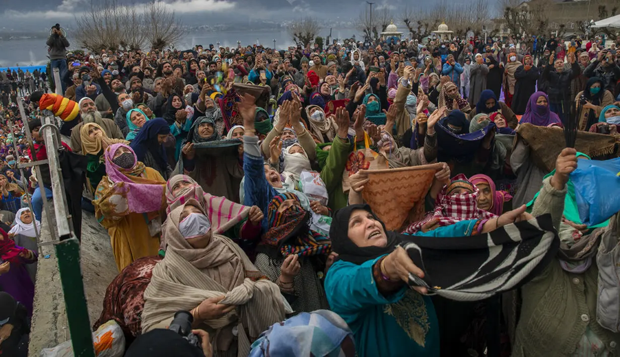 Umat muslim memanjatkan doa saat imam memamerkan peninggalan Nabi Muhammad pada peringatan Isra Miraj di Masjid Hazratbal, Srinagar, Kashmir, India, Jumat (12/3/2021). Ribuan muslim Kashmir berkumpul di Masjid Hazratbal yang menyimpan janggut Nabi Muhammad. (AP Photo/Dar Yasin)