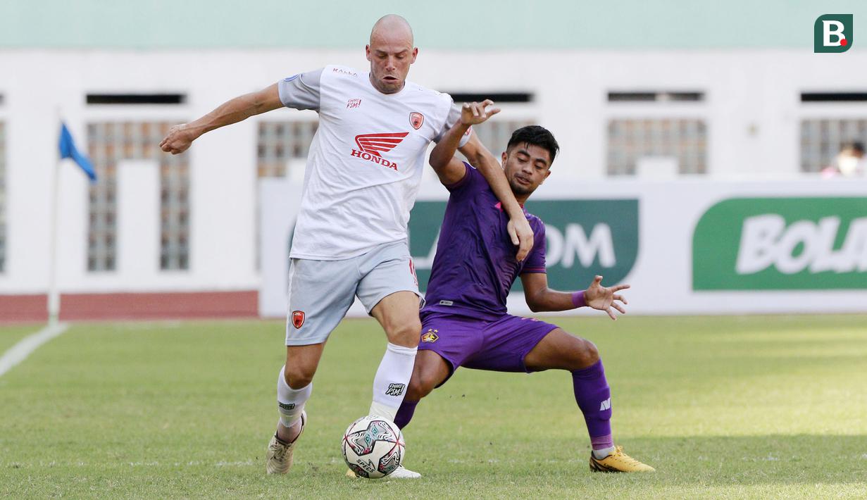 Pemain PSM Makassar, Anco Jansen (kiri) berebut bola dengan pemain Persik Kediri, Ibrahim Sanjaya dalam laga pekan ke-4 BRI Liga 1 2021/2022 di Stadion Wibawa Mukti, Cikarang, Kamis (23/9/2021). PSM menang 3-2. (Bola.com/M Iqbal Ichsan)