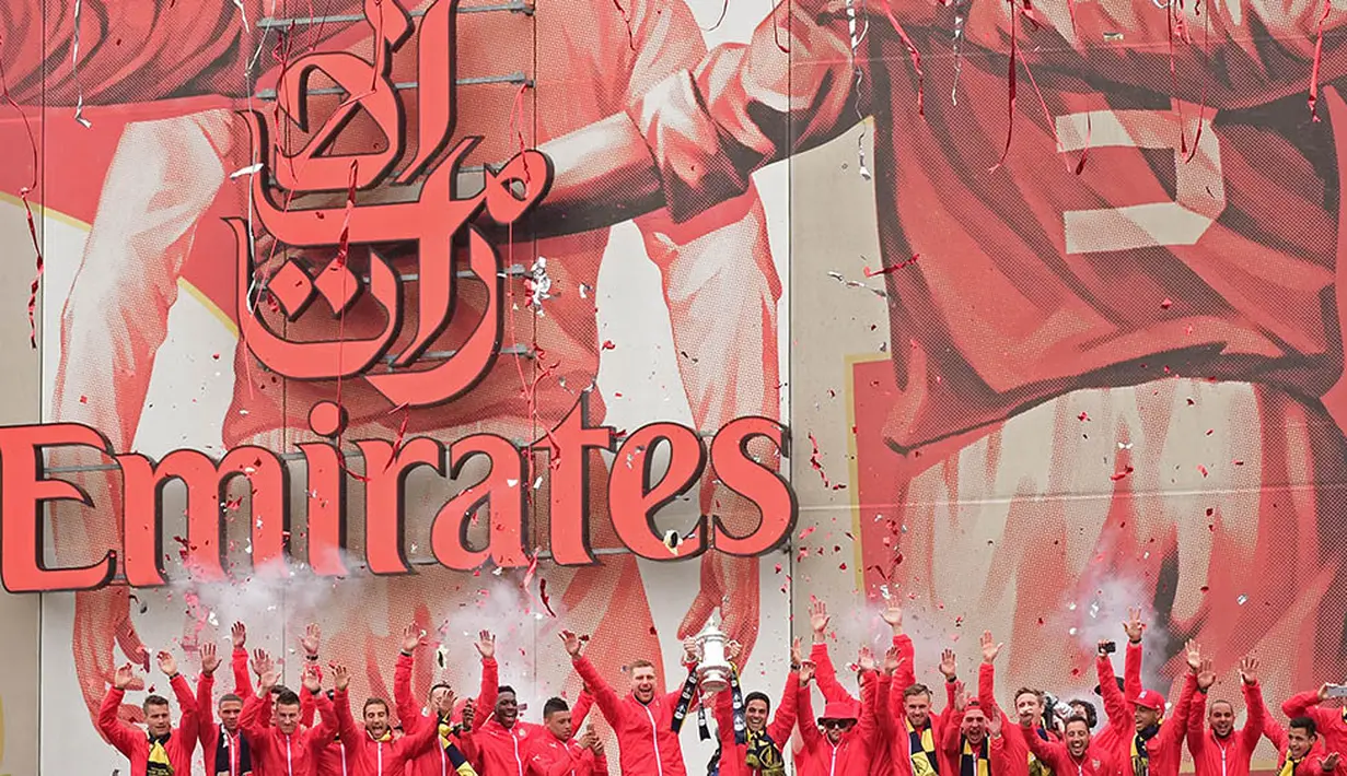 Para pemain merayakan sukses Arsenal meraih gelar Piala FA. Mereka konvoi keliling kota London untuk menyapa para fans. (AFP/Leon Neal)