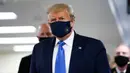 Presiden Amerika Serikat Donald Trump mengenakan masker saat menyusuri lorong dalam kunjungannya ke Pusat Kesehatan Militer Nasional Walter Reed di Bethesda, Maryland, Sabtu (11/7/2020). Trump memakai masker untuk pertama kalinya di depan umum selama pandemi COVID-19. (AP Photo/Patrick Semansky)